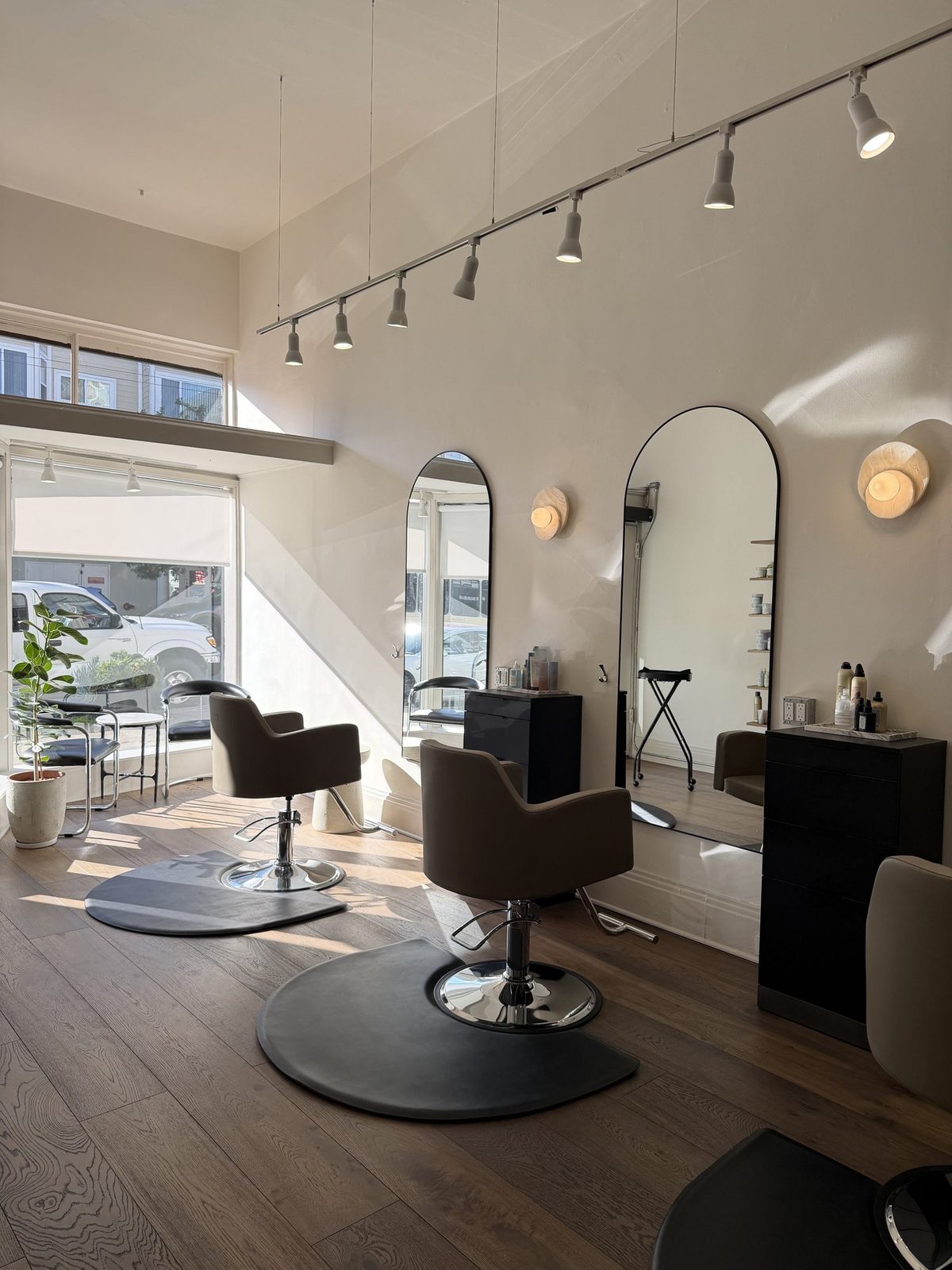 The Era Salon studio — styling chairs, arched mirrors, and warm daylight