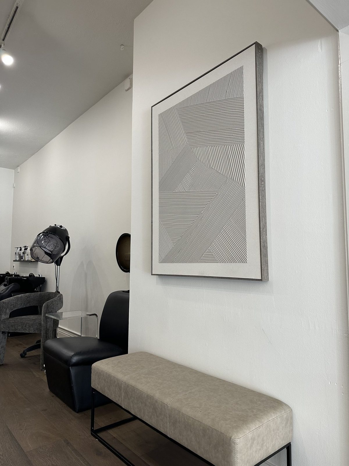 A quiet corner of the salon with a styling chair and framed art