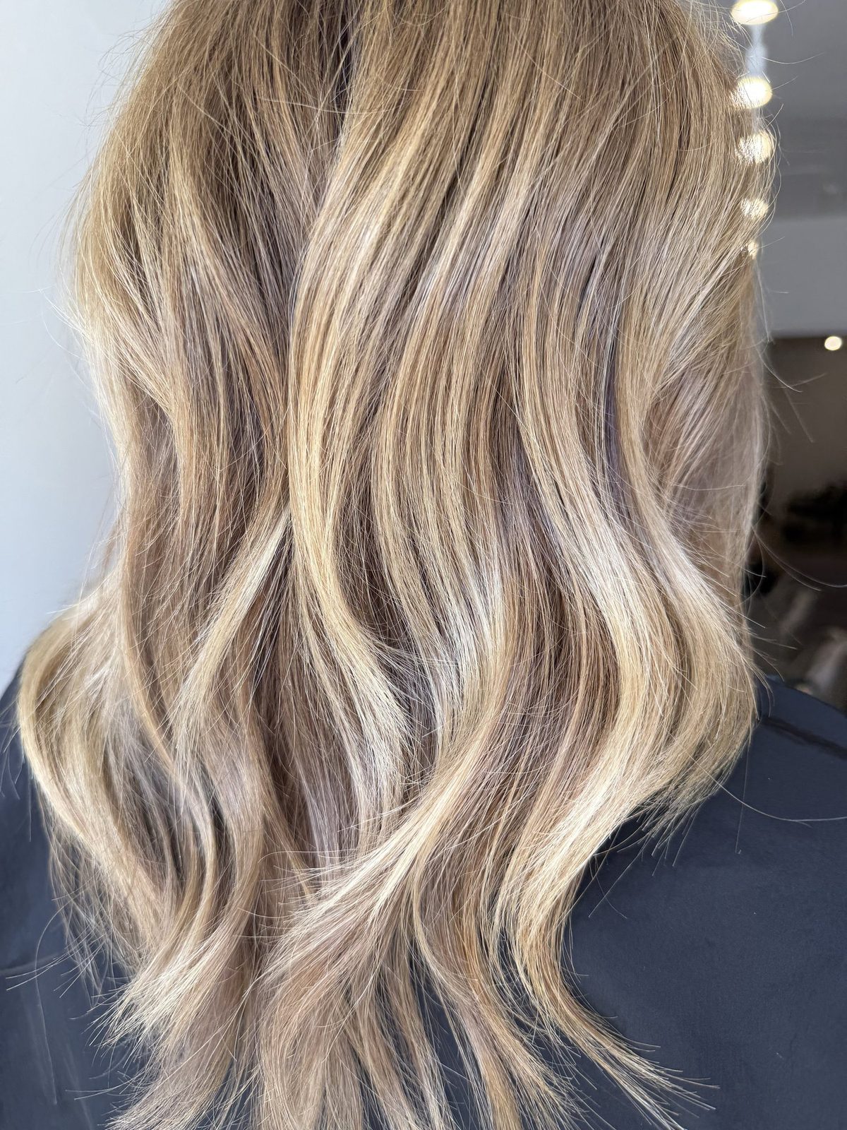 Long, lived-in blonde waves created at Era Salon