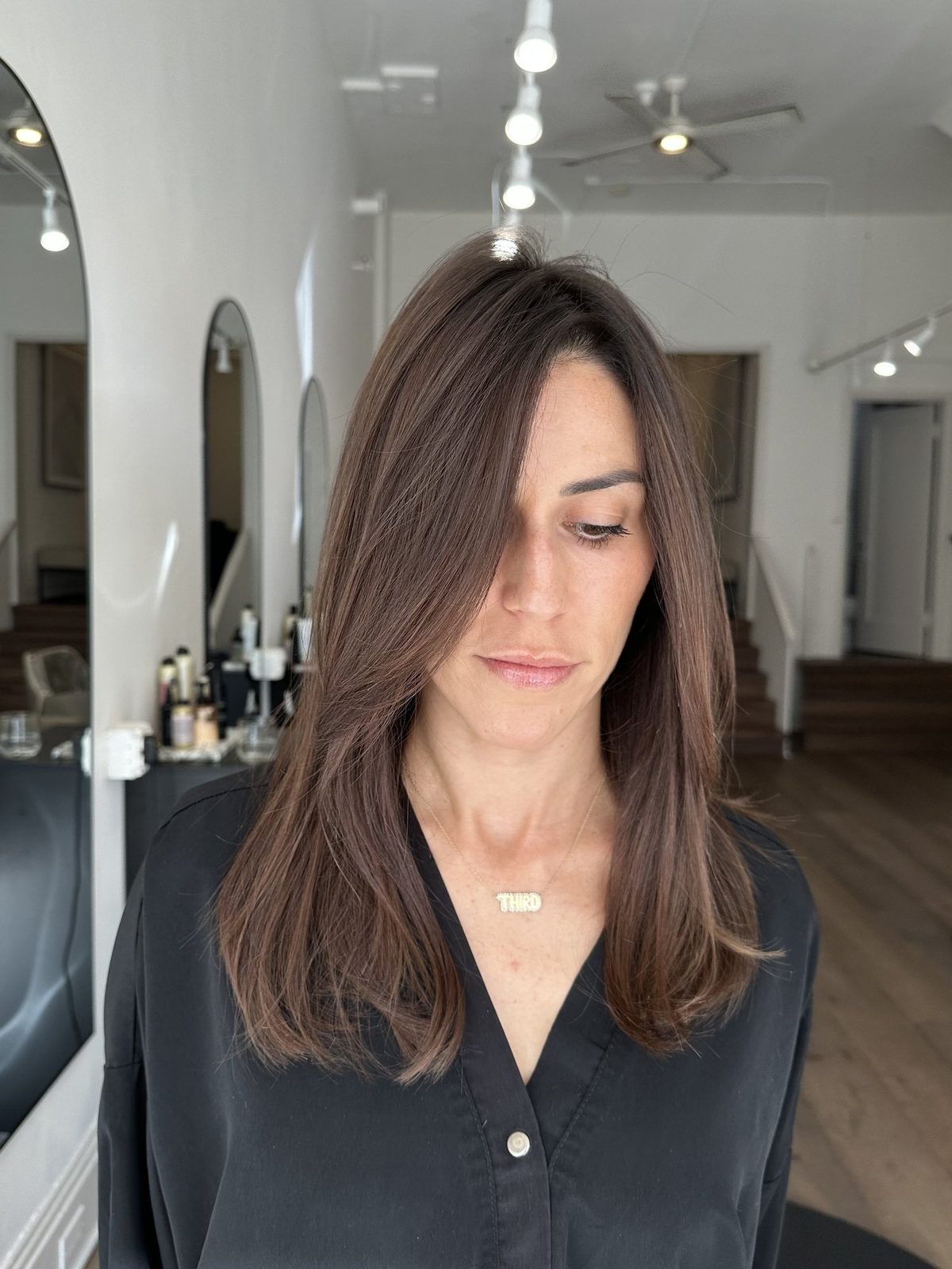 A softly layered brunette cut styled at Era Salon